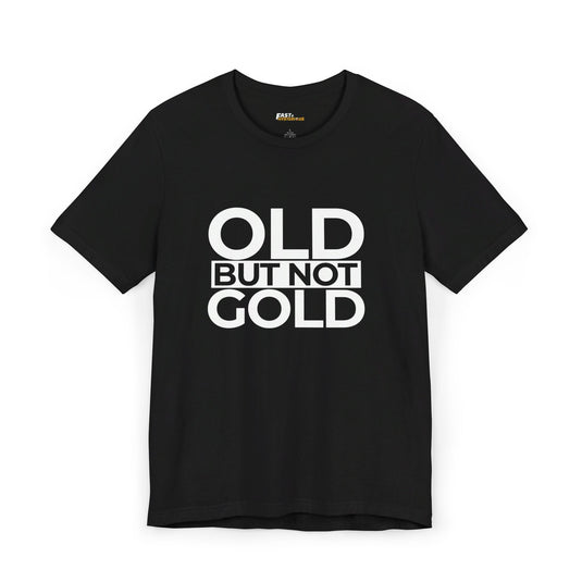 Black unisex tee featuring bold white text 'Old But Not Gold,' ideal for a sarcastic take on aging.