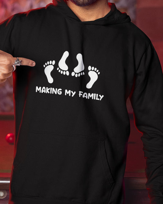 Black funny graphic hoodie with "Making My Family" text and footprint design, perfect for bold unisex humor lovers.