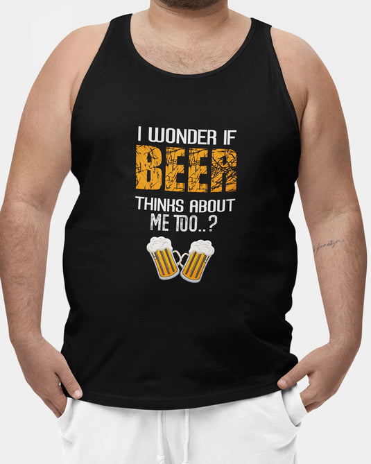 Model wearing a black graphic tank top with the humorous phrase "I wonder if beer thinks about me too..?" and beer mugs illustration, ideal for beer lovers, for men and women.