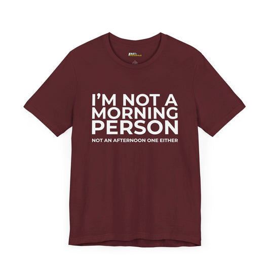 Maroon tee with a sarcastic message "I'm Not a Morning Person, Not an Afternoon One Either." Great for humor enthusiasts.