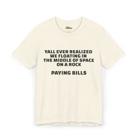 Natural-colored unisex tee with a sarcastic message about the absurdity of life, highlighting the fact that we’re all just paying bills on a floating rock.