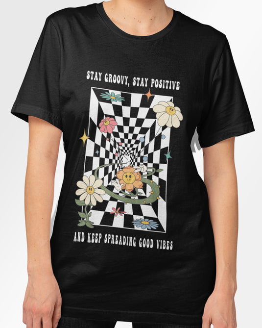 Black psychedelic graphic tee featuring a checkerboard pattern with smiling flowers and text promoting positivity and groovy vibes.