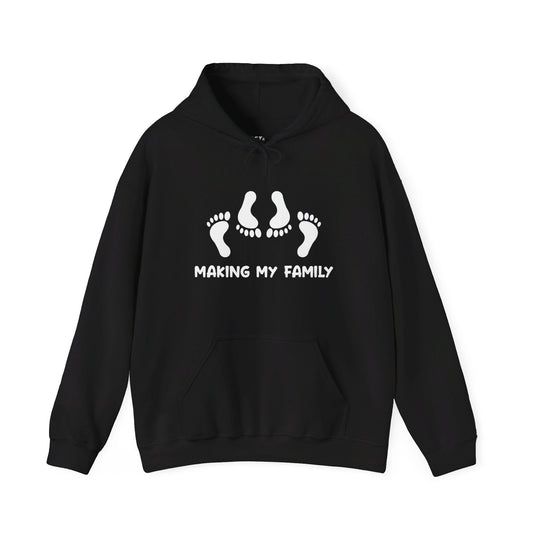 Black hoodie with "Making My Family" design, showcasing suggestive footprints, ideal for men who love sarcasm and humor.